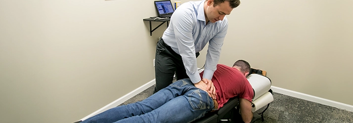 Chiropractor Warsaw IN Matthew Palladino Adjusting Patients Back